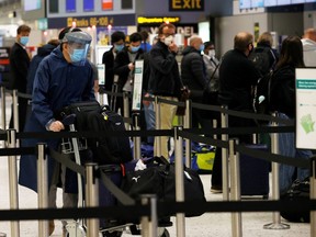 A passenger wearing a protective face mask and visor queues to check in at Manchester Airport, following the outbreak of the coronavirus disease (COVID-19), Manchester, Britain, June 8, 2020.