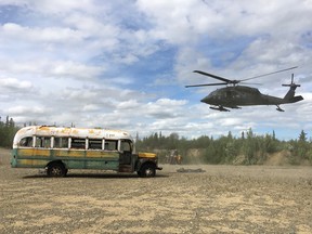 An Alaska Army National Guard UH 60 Blackhawk helicopter hovers near "Bus 142", made famous by the Into the Wild book and movie, after it was depostied by a CH-47 Chinook helicopter on the ground east of the Teklanika River alongside the Stampede Road, west of Healy, Alaska, U.S. June 18, 2020.
