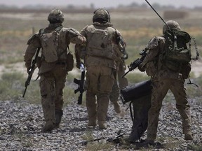 Canadian soldiers help a comrade, center, get on a helicopter after he was injured in an IED blast during a patrol outside Salavat, in the Panjwayi district, southwest of Kandahar, Afghanistan on June 7, 2010.