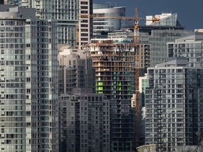 A condo tower under construction is pictured in downtown Vancouver on February 9, 2020. A report commissioned by the B.C. government says insurance premiums for condominium buildings have increased by as much as 40 per cent year over year while deductible costs have tripled. Blair Morrison, chief executive officer of The B.C. Financial Services Authority, says the state of the insurance market for condo buildings is unhealthy.