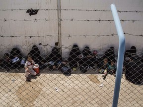 Women and children related to fighters of the Islamic State group wait to board buses and trucks, leaving the overcrowded a an overcrowded al-Hol camp to return to their homes on June 3, 2019, in Hasakeh province, Syria.