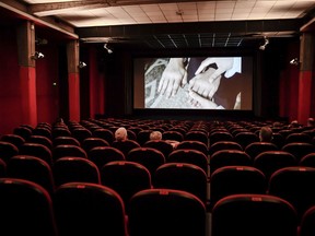 People sit in a cinema in Milan, Italy, Monday, June 15, 2020. A new poll suggests two-thirds of Canadians don't want to relax the physical distancing rules imposed to curb the spread of COVID-19. And if they were relaxed, fewer than half would feel comfortable taking part in activities that would bring them closer to other people, like going to a movie theatre.