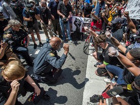 Toronto Police Chief Mark Saunders and other officers kneel on Toronto's Yonge Street at a March For Change rally in remembrance of George Floyd, who was killed by police in Minneapolis, on June 5, 2020.