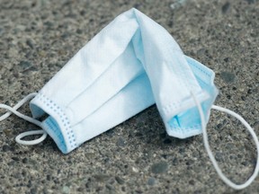 A discarded surgical mask is seen on the sidewalk in downtown Vancouver, Monday, April 20, 2020