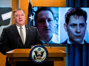 Pictures of Michael Spavor, a Canadian businessman, and Michael Kovrig, a former Canadian diplomat, both detained in China since December 2018, are displayed on a video monitor as U.S. Secretary of State Mike Pompeo speaks during a news conference at the State Department in Washington, U.S., July 1, 2020.