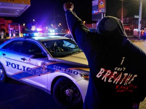A man stands in front of a police car during a protest against the deaths of Breonna Taylor by Louisville police and George Floyd by Minneapolis police, in Louisville, Ky., on June 1.