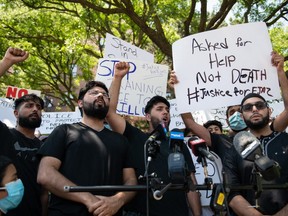 Khizar Shahzad, left, Hashim Choudhary, second from left, and Hassan Choudhary, centre, shout for justice at the end of a press conference in front of the apartment building where their uncle, Ejaz Choudry, a 62-year-old man who family members said was experiencing a schizophrenic episode, was shot by Peel Police and died at the scene the previous night, in Mississauga, Ont., Sunday, June 21, 2020.