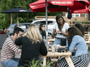 A server takes orders on the patio at a restaurant in Ottawa on its first day of reopening as Ontario moves into Stage 2 of its plan to lift COVID-19 lockdown measures, on June 12, 2020.