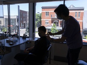 A man get his hair cut by hairdresser Armanno at the Biosthetique Salon in Montreal, on Monday, June 15, 2020. Hairdressers, tattoo parlours and other personal-care businesses in the Greater Montreal reopened Monday.
