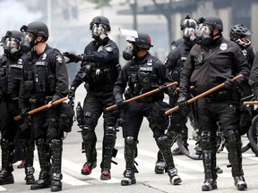 Seattle police form a line after deploying pepper spray and flash-bang devices during a protest against the death in Minneapolis police custody of George Floyd, in Seattle, Washington, U.S. May 31, 2020.