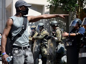 A protester points toward police as they face off with demonstrators near the White House as they protest the death of George Floyd, who died in police custody in Minneapolis, in Washington, D.C., on June 3, 2020.