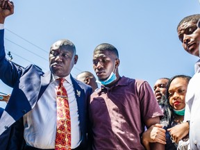 George Floyd's son, Quincy Mason Floyd (C R) and family Attorney Ben Crump (C L) and other family members visit on June 3, 2020, the site where George Floyd died in Minneapolis, Minnesota.