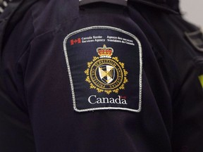 A Canadian Border Services agent stands watch at Pearson International Airport in Toronto on Tuesday, December 8, 2015. The Canada Border Services Agency says they turned back 21 people who tried to enter the country from the U.S. in May to claim asylum.