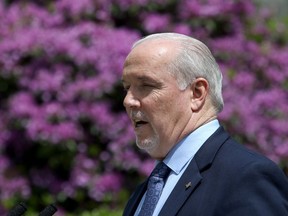 B.C. Premier John Horgan provides the latest update on the COVID-19 response in the province during a press conference from the rose garden at Legislature in Victoria, B.C., on Wednesday, June 3, 2020. British Columbia's premier says calls for defunding police are a simplistic approach to a complex problem.