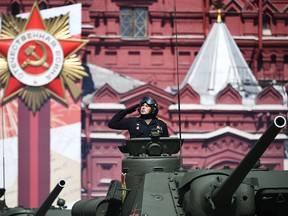 A WWII SU-100 crew member salutes during a Victory Day military parade in Red Square marking the 75th anniversary of the victory in World War II, on June 24, 2020 in Moscow, Russia.