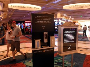 Guests walk by a kiosk that dispenses complimentary masks, hand sanitizer and gloves at Bellagio Resort & Casino on the Las Vegas Strip after the property opened for the first time since being closed on March 17 because of the coronavirus (COVID-19) pandemic on June 4, 2020 in Las Vegas, Nevada.