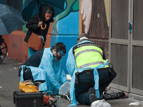 Paramedics treat a man suffering a drug overdose in Vancouver's Downtown Eastside, May 2, 2020.