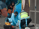 Paramedics treat a man suffering a drug overdose in Vancouver's Downtown Eastside, May 2, 2020.