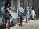 People keep their distance while lining up outside a clothing store in Toronto, June 15, 2020.