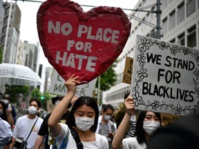 People take part in a Black Lives Matter protest march in central Tokyo on June 14, 2020. - The protests are part of a worldwide movement following the killing in the United States of African-American man George Floyd who died after a white policeman knelt on his neck for several minutes.
