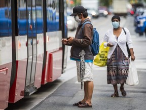 TTC riders wearing a face masks board a streetcar at the intersection of Spadina Ave. and Queen St. W. in Toronto, Ont.  on Thursday June 11, 2020.