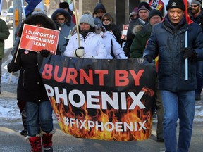 Supporters march across Broadway at Smith Street during a rally hosted by the Public Service Alliance of Canada in Winnipeg on Wed., Feb. 19, 2020.