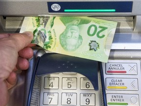 Money is removed from a bank machine Monday May 30, 2016  in Montreal.