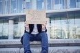 man holding sign that says 'I lost my job due to coronavirus