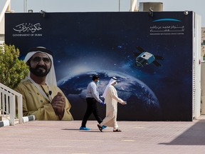 Employees pass a sign board displaying an image of Mohammed bin Rashid al-Maktoum, Dubai’s ruler, at the Mohammed Bin Rashid Space Centre in Dubai, United Arab Emirates, on Tuesday, July 28, 2020.
