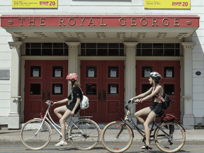 Cyclists ride past The Royal George Theatre in Niagara-On-The-Lake, home to the Shaw Festival, in June.