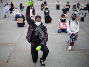 In this file photo taken on June 5, 2020 a protester makes a Black Lives Matter fist at a demonstration in Trafalgar Square in central London, to show solidarity in the wake of the killing of George Floyd.