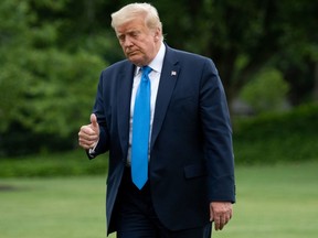 In this file photo taken on July 11, 2020 US President Donald Trump gives a thumbs up and walks from Marine One after arriving on the South Lawn as he returns to the White House in Washington, DC.