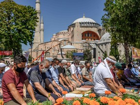 Men perform the Friday prayer outside the Hagia Sophia in Istanbul, on July 24.