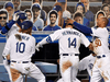 Los Angeles Dodgers players congratulate Enrique Hernandez for hitting a home run against the San Francisco Giants while ever-cheery cardboard cutout fans watch.
