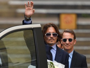 Actor Johnny Depp waves as he leaves the High Court in London, Britain.