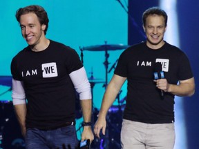 Craig, left, and Marc Kielburger walk on to the stage at the WE Day event at the Scotiabank Saddledome in Calgary on Wednesday October 26, 2016.