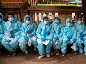 Health workers wearing Personal Protective Equipment (PPE) wait for instructions to conduct a door-to-door medical screening drive for COVID-19 coronavirus, at a residential area in Mumbai on July 20, 2020.