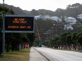 motorway sign reads "Be kind and stay calm" along a street devoid of cars in response to the COVID-19 coronavirus outbreak in Wellington on April 20, 2020.