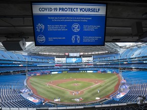 A Covid-19 warning sign is seen over the diamond at Rogers Centre on July 9, 2020 in Toronto, Canada.