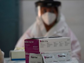 A medical staff wearing personal protective equipment sits as she waits for people to be tested with rapid antigen test (RAT) for the COVID-19 coronavirus.