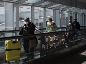 People leave the terminal after arriving at Pearson International Airport in Toronto on Monday, March 16, 2020.