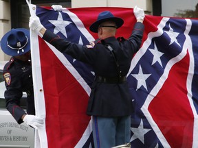 A Mississippi Highway Safety Patrol honor guard folds the retired Mississippi state flag after it was raised over the Capitol grounds one final time in Jackson, Miss., in a July 1, 2020 file photo.