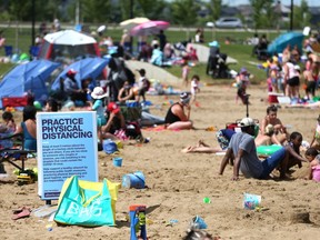 Beachgoers and water enthusiasts are shown on a stretch of beach in Chestermere, Alta., east of Calgary on Thursday, July 16, 2020.