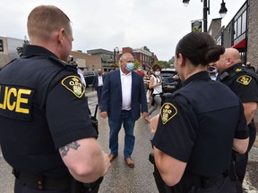 Ontario Premier Doug Ford greets local members of the O.P.P. in Leamington, Ont., on Thursday, July 16, 2020. A large swath of Ontario will be moving on to the next phase of the provincial government's COVID-19 recovery plan today.