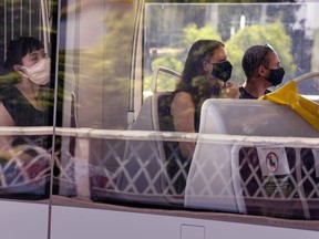 Toronto Transit Commission riders wear masks as they ride a streetcar in Toronto on Thursday, July 2, 2020.