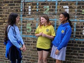 Students at St. John's Primary School in the Southwest London community of Fulham chat on the final day of the school year on July 16, 2020. Although schools in Britain closed in late March due to the coronavirus pandemic, primary schools reopened in June.
