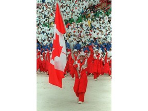 World figure skating champion Brian Orser carries the Canadian flag as he leads the Canadian Olympic team into McMahon Stadium during the opening ceremonies of the XV Olympic Winter Games in Calgary, Saturday, Feb. 13, 1988.