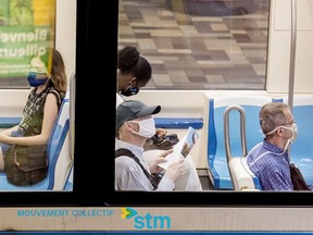 People wear face masks as they commute on a metro in Montreal, Sunday, July 12, 2020. Since July 13, Quebec has made masks mandatory for anyone riding on public transit, with the only exceptions being those who can't wear one for health reasons.