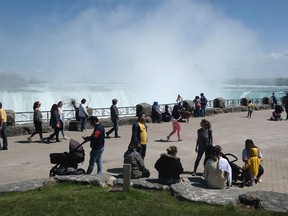 A crowdsourced survey of Canadian parents finds that nearly three-quarters of respondents are concerned about their children's social engagement during the pandemic. Families walk along the promenade in front of Niagara Falls, in Niagara Falls, Ont., May 16, 2020.