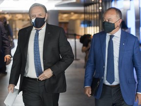 Quebec Premier Francois Legault, left, and Health Minister Christian Dube arrive for a news conference in Montreal, Monday, July 13, 2020, as the COVID-19 pandemic continues in Canada and around the world.